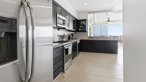 Una cucina moderna con un frigorifero in acciaio inossidabile, un forno integrato e un microonde.