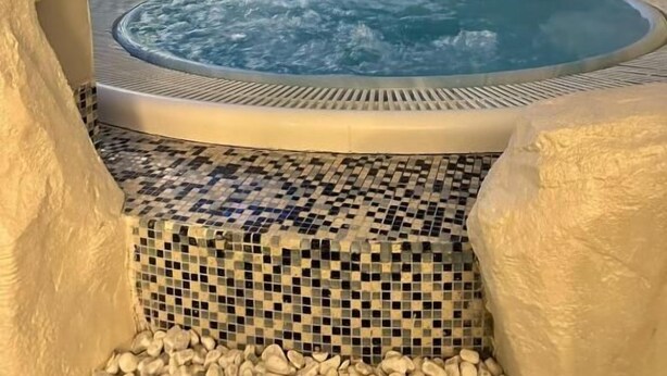 A hot tub with a tiled floor, a mosaic wall, and a large window. - Acquario House centro storico di Genova (Genoa)