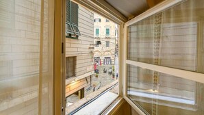 A narrow corridor with a window overlooking a street. - Acquario House centro storico di Genova (Genoa)