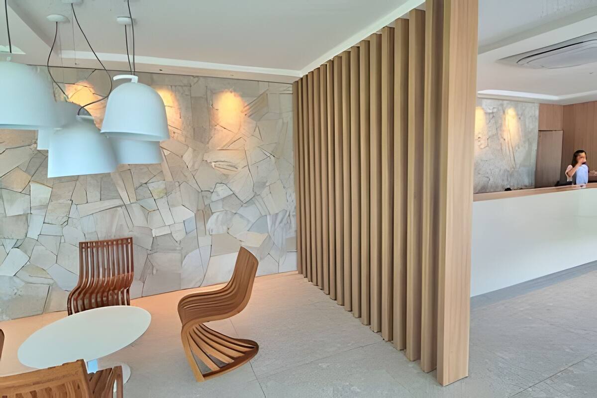 A modern reception area with a stone wall, wooden paneling, and contemporary furniture.