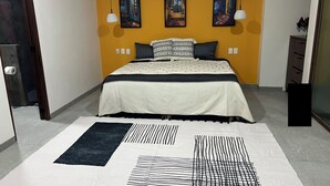 Ein Schlafzimmer mit einem Bett, einem Teppich und drei Bildern an der Wand.