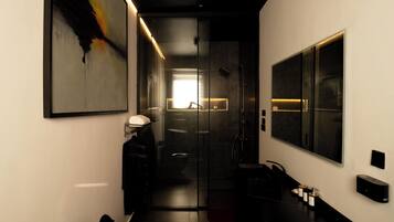 A modern bathroom with a large mirror, a black chair, and a minimalist design.