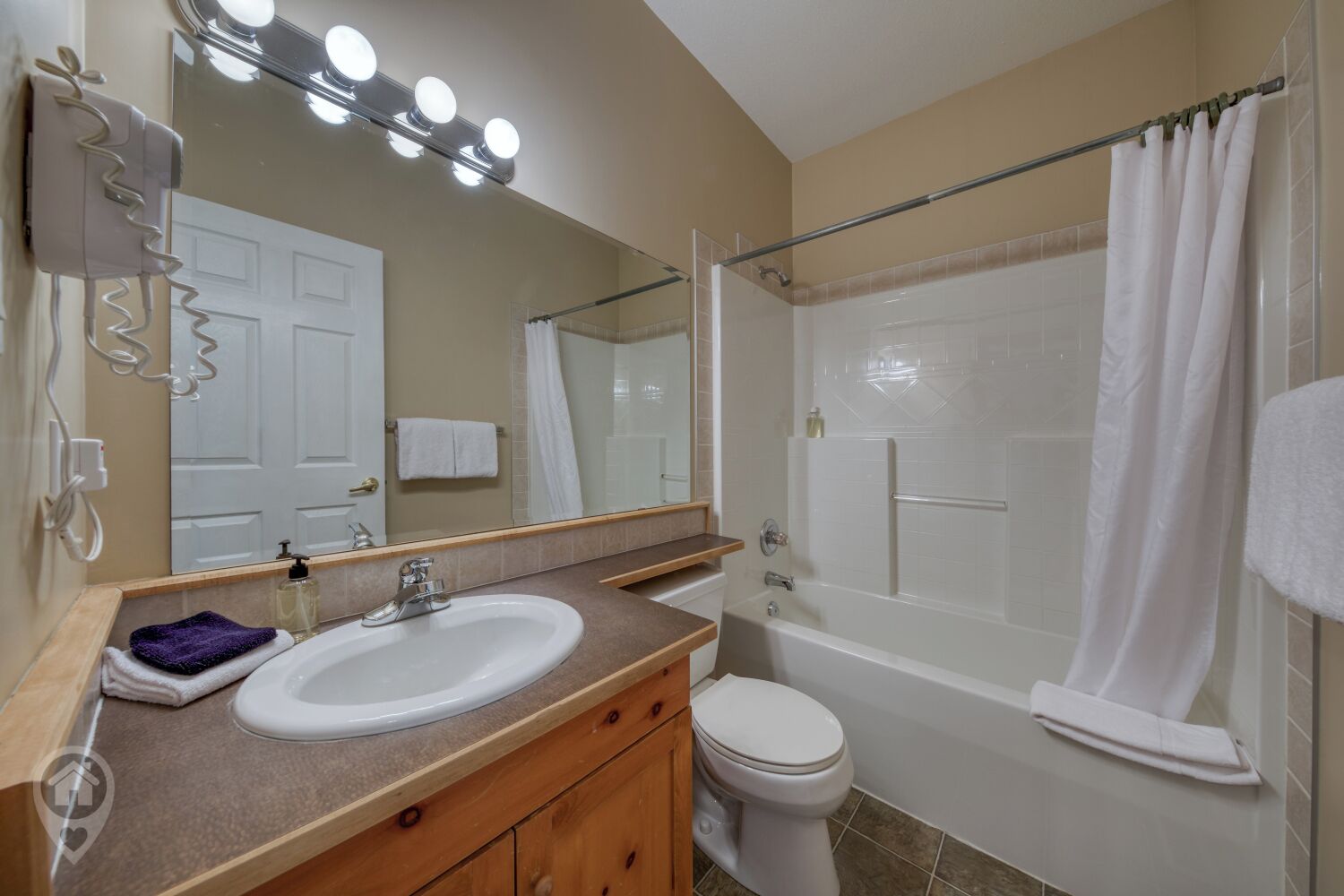 Un baño con lavamanos, espejo y ducha.