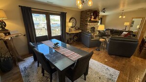 A living room with a fireplace, a dining area with a table and chairs, and a sofa. - Restoration of the Rockies- Great Cabin Close to Town with Room for All (Lake City)
