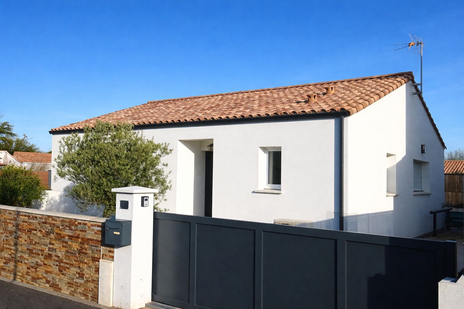 A single-story house with a tiled roof, a small window, and a visible chimney.