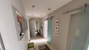 A hallway with a green cushioned bench, a patterned rug, and a door with a towel rack. - Modern, well-equipped 5* vacation apartment on the sunny side of Linz am Rhein (Linz am Rhein)