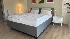 A modern bedroom with a large bed, a bedside table with a lamp, and three framed pictures on the wall. - Modern, well-equipped 5* vacation apartment on the sunny side of Linz am Rhein (Linz am Rhein)