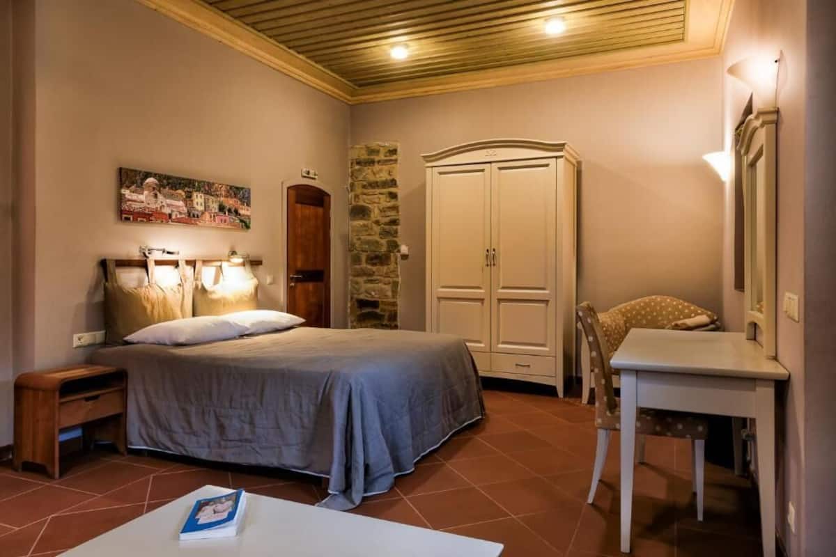 Une chambre à coucher comprenant un lit, une table de chevet, une commode et une chaise.