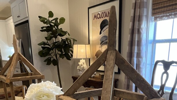 Una stanza con struttura in legno, candele e un'elegante composizione floreale bianca.