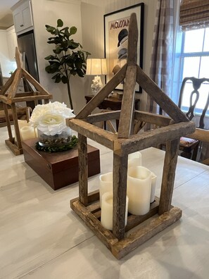 Um quarto com estrutura de madeira, velas e um arranjo de flores brancas.