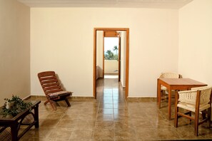 A room with a wooden table and chairs, a potted plant, and a view through an open doorway. - Private Studio-Pool- Walk Everywhere La Punta-Kitchen & Wi-Fi-Optional Breakfast (brisas de zicatela)