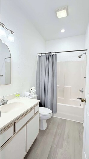 A modern bathroom with a white sink, toilet, and shower. - Peaceful Golf Course Retreat,2BR First-Floor Condo (Myrtle Beach)