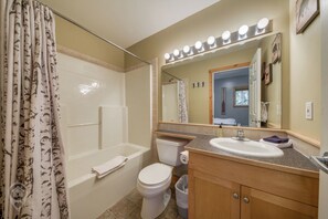 Une salle de bain équipée d’une baignoire, de toilettes, d’un lavabo et d’un meuble-lavabo.
