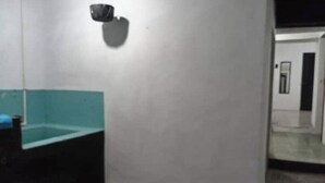 Un bagno con un lavandino blu, uno specchio e un portalampada a parete.