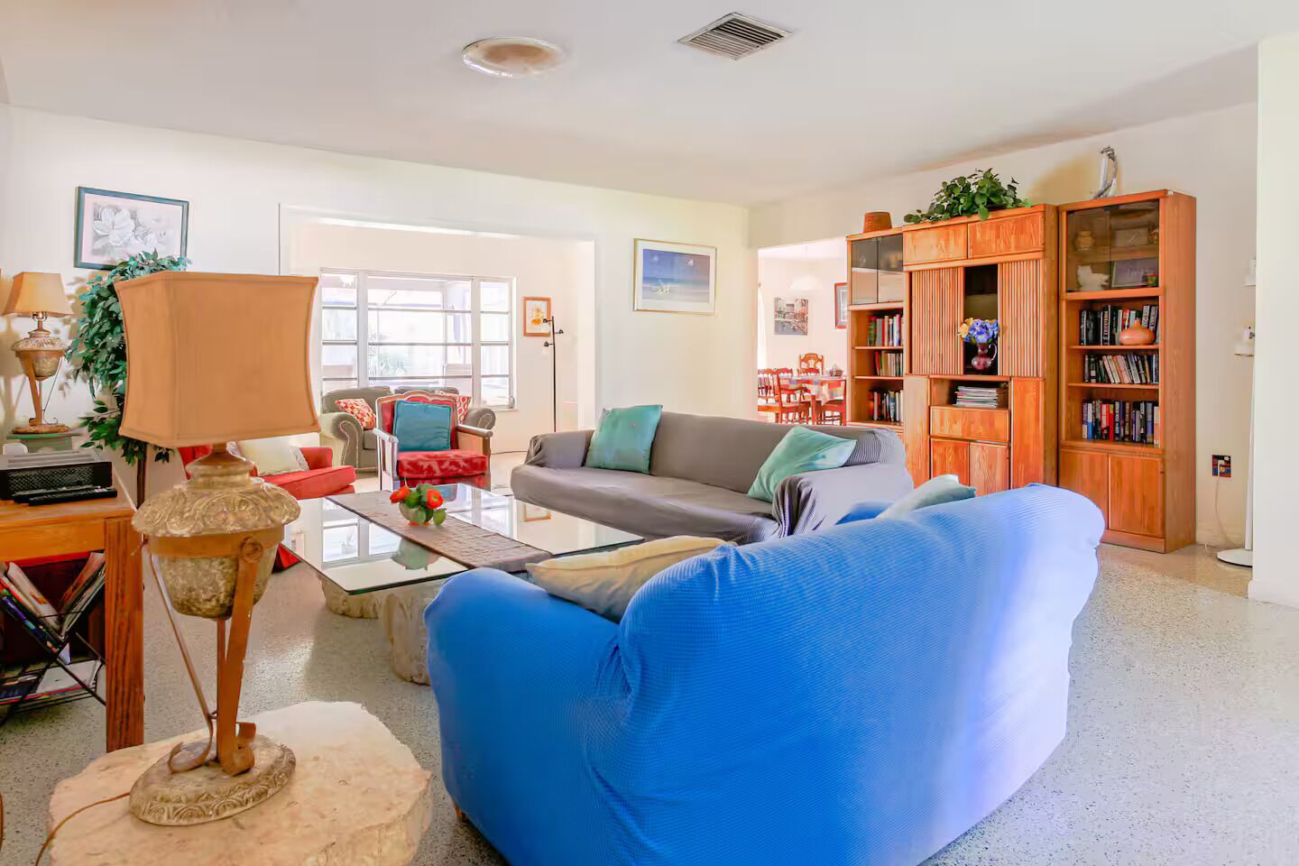 A living room with a sofa, a coffee table, a lamp, and a bookshelf.