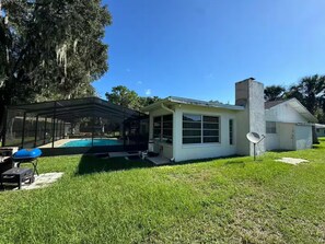 A house with a pool, a covered patio, and a satellite dish. - Pool Home, Dock on the Rainbow River & 7 kayaks! (Dunnellon)