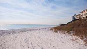 A beach with a sandy path leading to a building with multiple balconies overlooking the ocean. - Sea La Vie Corner Condo at Gulf Place Wraparound Balcony & Beach Access (Santa Rosa Beach)