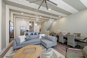 Ein modernes Wohnzimmer mit Ecksofa, Esstisch und Stühlen.