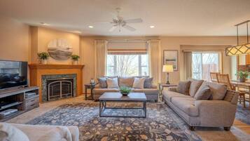 A living room with a fireplace, sofa, coffee table, and television.