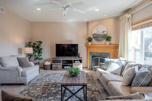 A living room with a fireplace, a television, and two sofas. - Spacious Modern 5-Bed Home –  Near Twin Cities (Rosemount)
