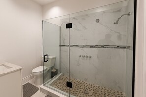 Ein modernes Badezimmer mit Duschkabine, Toilette und Waschbecken.