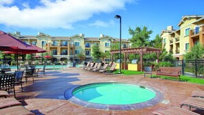 A pool area with lounge chairs, a gazebo, and a building with balconies. - Available for Super Bowl Weekend!  1:15-hour drive from Santa Clara. (Napa)