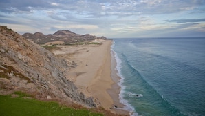 A coastal landscape with a sandy beach, rocky cliffs, and a view of the ocean. - 3-bedroom house in delightful Cabo San Lucas, AMAZING 1 week option (Cabo San Lucas)