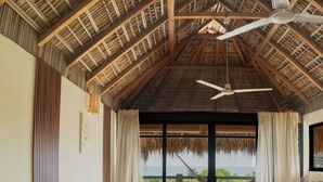A hotel room with a thatched roof, two beds, a balcony with a view, and a ceiling fan. - Private Studio Palapa Mango- Pool- Ocean View - La Punta (brisas de zicatela)