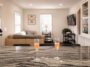 A living room with a sofa, a coffee table, and two glasses of a beverage.