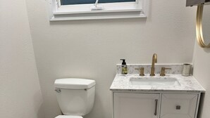 Un baño con inodoro, lavabo y armario.