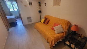 Una habitación con un sofá, una lámpara y una mesita.