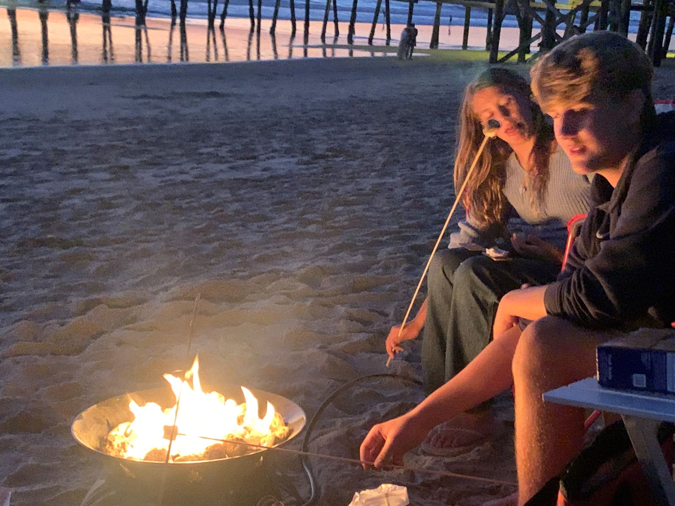 Une scène de plage avec un foyer au premier plan.