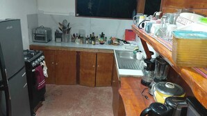 A compact kitchen with wooden cabinets, a gas stove, a toaster, and a sink.