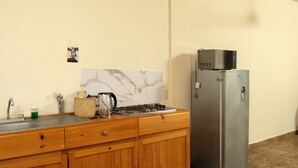 Eine Küche mit Holzschränken, einem Edelstahl-Kühlschrank, einem Gasherd und einer Marmor-Spritzschutzwand.