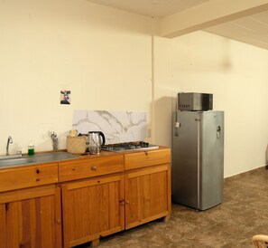 A kitchen with wooden cabinets, a stainless steel refrigerator, a gas stove, and a marble backsplash. - Private 1BR - Pool- AC- La Punta - Private Kitchen & Bath (brisas de zicatela)