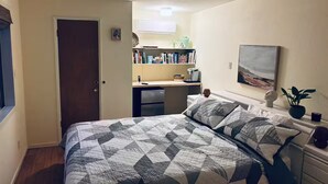 Ein Schlafzimmer mit einem Bett, Nachttischen, einem Schreibtisch und einem Stuhl.