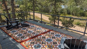 Una terraza con piso estampado, una silla y una mesa.