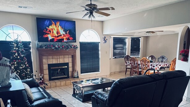 A living room with a fireplace, a TV, a Christmas tree, and a dining area. - Charming 3-bedroom house with Fireplace & Mountain View’s in Rio Rancho (Rio Rancho)