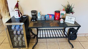 A kitchenette with a coffee maker, a water dispenser, a mug, a sign, and a small Christmas decoration. - Charming 3-bedroom house with Fireplace & Mountain View’s in Rio Rancho (Rio Rancho)