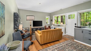 A living room with a sofa, chairs, a TV, and a dining area. - Private Urban Forest Hideaway in the Heart of Portland with AC (Portland)