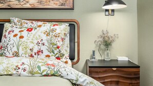 A neatly arranged bedroom with a bed, a bedside table with a lamp, and a wall-mounted painting. - Private Urban Forest Hideaway in the Heart of Portland with AC (Portland)