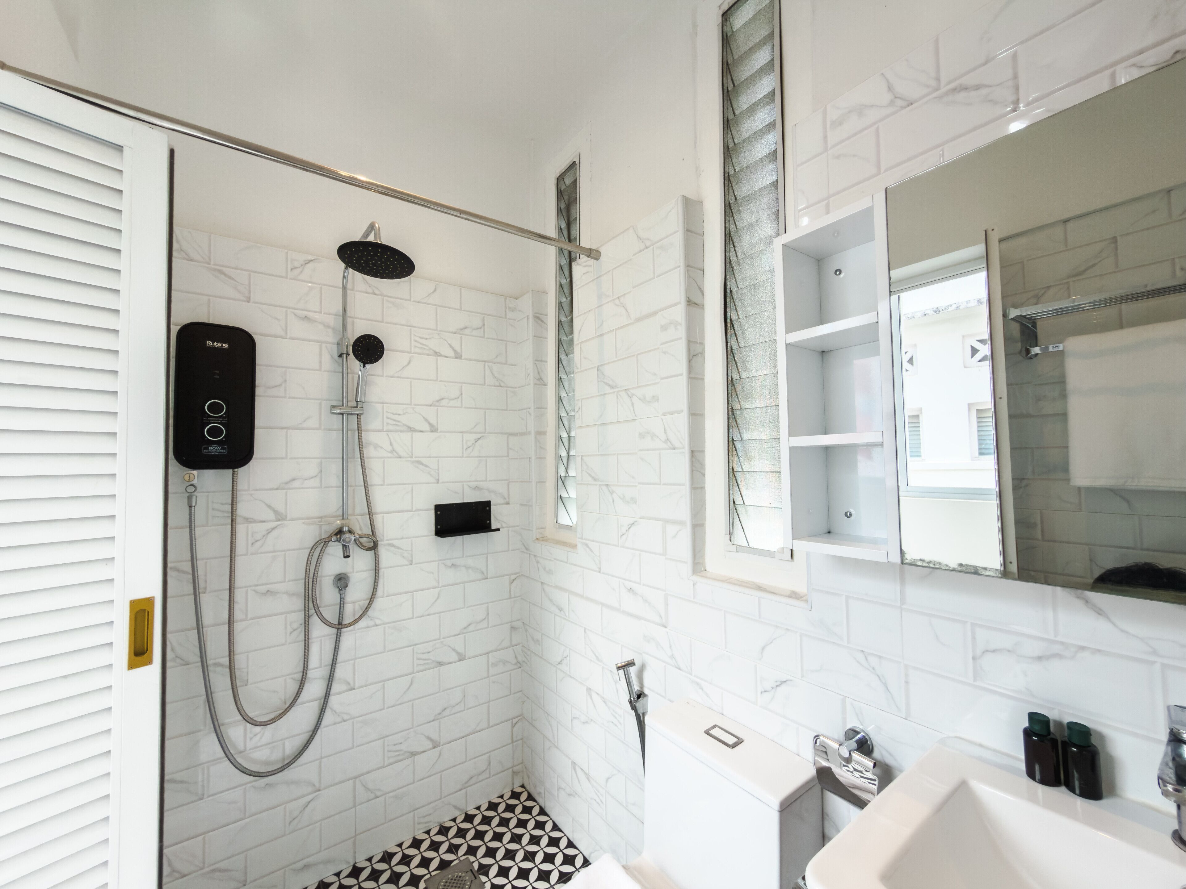 A modern bathroom with a shower, toilet, and sink.