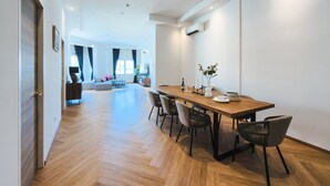 Una sala de estar moderna con una mesa de comedor de madera, sillas y un sofá.