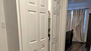 A hallway with wooden flooring and white doors.