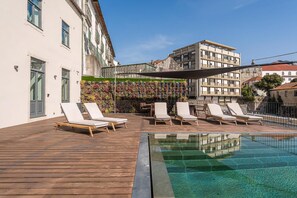 A rooftop pool with lounge chairs, a wooden deck, and a colorful vertical garden. - Guestready - D. Hugo Boutique Hotel B&B (Porto)
