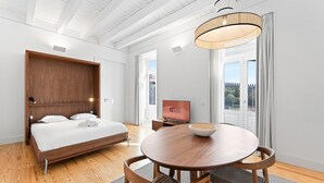 A modern hotel room with a wooden bed, a round dining table, and a television displaying "GUEST READY". - Guestready - D. Hugo Boutique Hotel B&B (Porto)