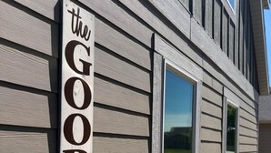 A building with a sign reading 'the GOOD life' and flower boxes on the windows. - The Good Life - Okoboji cabin in Bridges Bay (Arnolds Park)