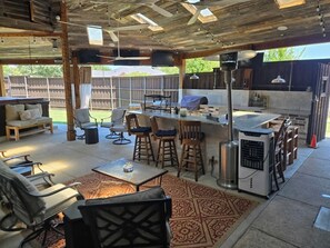 An outdoor patio area with a bar, seating, and a grill. - Movie Room | Huge Patio|Hot Tub|Near Lake & Frisco (Little Elm)