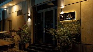 Un edificio con un letrero que dice "78 I AM LIVING" y un coche estacionado.