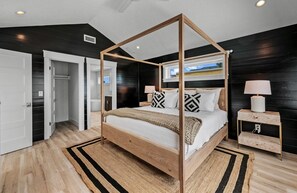 A four-poster bed with a wooden frame, white bedding, and patterned pillows. - Stunning Home w/ Pool, Slide & Spa & Rooftop Views (Sarasota)